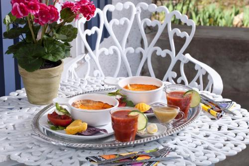 a white table with a tray of food and drinks at Cliff Cottage Inn, Downtown Bed & Breakfast in Eureka Springs