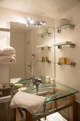 La salle de bains est pourvue d'un lavabo en verre et d'un miroir. dans l'établissement Les Hauts de Gageac Maison d'Hôtes de Charme, à La Roque-Gageac