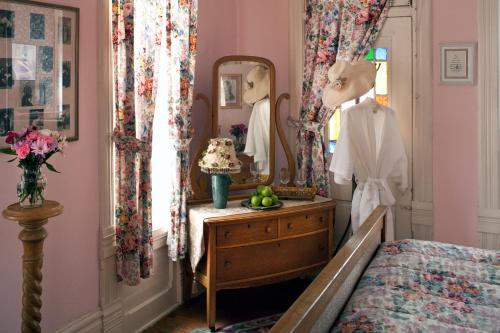 a dressing room with a bed and a mirror at Cliff Cottage Inn, Downtown Bed & Breakfast in Eureka Springs
