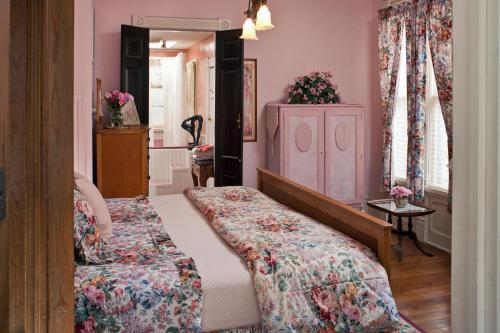 a bedroom with a bed and a dresser at Cliff Cottage Inn, Downtown Bed & Breakfast in Eureka Springs
