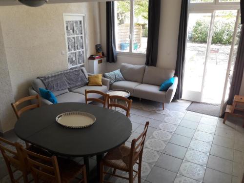 a living room with a table and a couch at La Marelle in Avrillé-les-Ponceaux