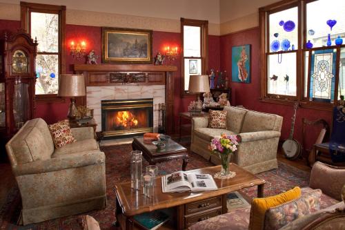 a living room filled with furniture and a fireplace at Cliff Cottage Inn, Downtown Bed & Breakfast in Eureka Springs
