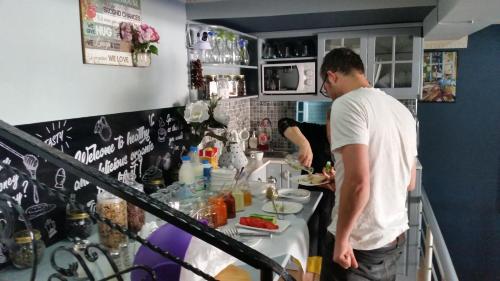 a man and a woman preparing food in a kitchen at Funky Guest House & Adventures in Përmet