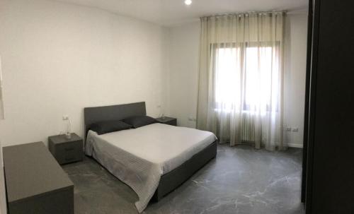 Un dormitorio con una cama y una ventana grande. en Venetian Aesthetic Apartment, en Mestre