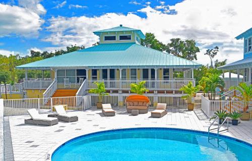 a house with a swimming pool in front of a house at Dolphin Point Villas in Key Largo