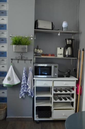 a small kitchen with a microwave on a shelf at La douceur de Cassis in Cassis