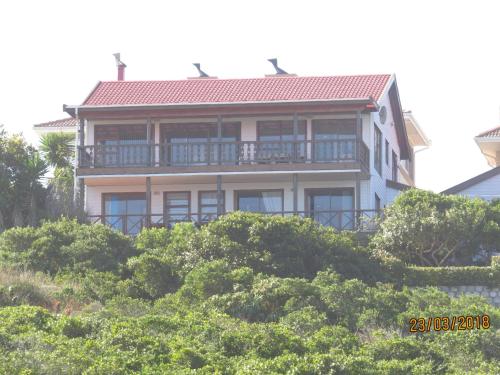a large house on top of a hill with trees at At Whale-Phin Guest House in Reebok