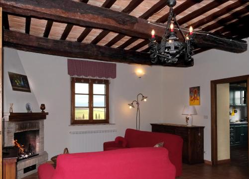 a living room with a red couch and a fireplace at Podere Cacchini in Pienza