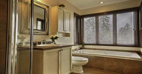 a bathroom with a tub and a toilet and a sink at Aiglon by Rendez-Vous Mont-Tremblant in Mont-Tremblant