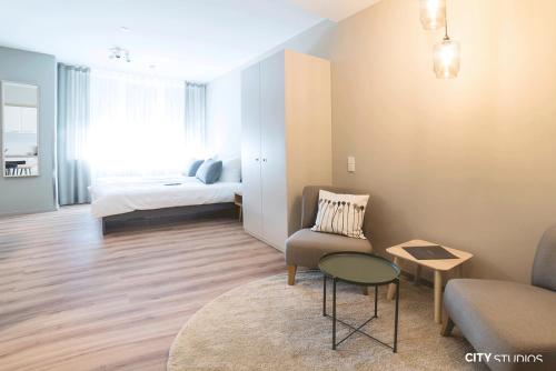 una sala de estar con un sofá y una cama en City Studios, en Heidenheim an der Brenz