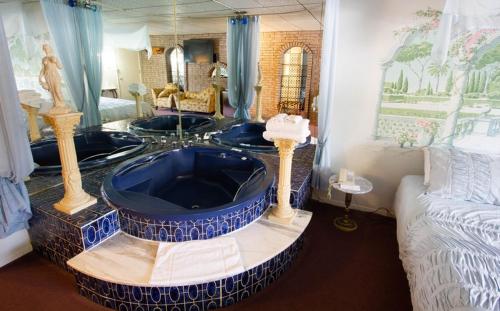 Auberge La Rocaille في شاوينيجان: حمام مع حوض أزرق كبير في الغرفة