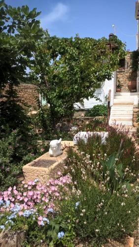 a garden with a statue in the middle of flowers at PATMOS Mathios Studios- apartments in Patmos
