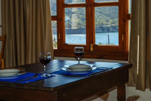 a table with two glasses of red wine on it at PATMOS Mathios Studios- apartments in Patmos