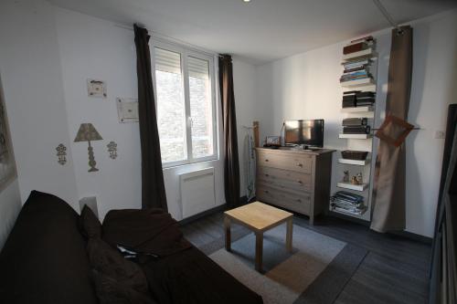 - un salon avec un canapé, une commode et une fenêtre dans l'établissement La Dieppoise, à Dieppe