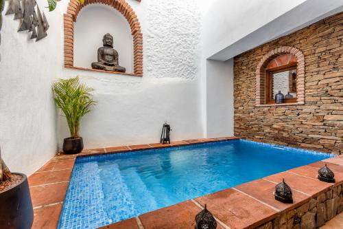 a swimming pool in a house with a stone wall at No 9 Competa Private Holiday Rental in Cómpeta