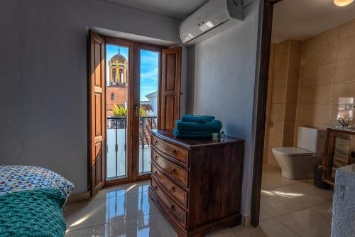 a bedroom with a dresser and a bathroom with a window at No 9 Competa Private Holiday Rental in Cómpeta