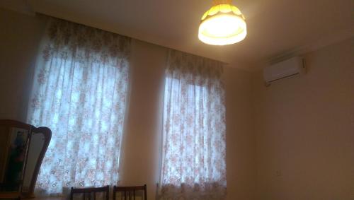 a room with a window with curtains and a light at Doors in Kutaisi