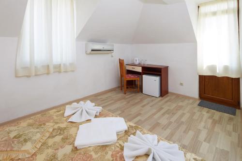 um quarto com uma secretária e uma cama com lençóis brancos em Gloria Holiday House em Nesebar
