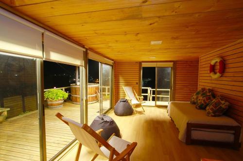a living room with a couch and chairs on a deck at Pupuya Vista Hermosa in Navidad
