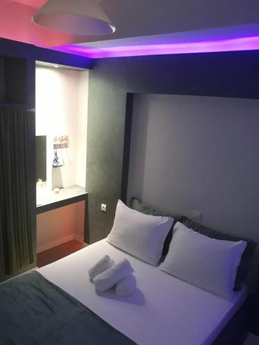 a bedroom with a white bed with a purple light at Filoxenia Apartments in Skala Sotiros