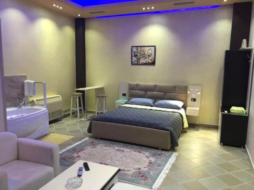 1 dormitorio con cama, sofá y bañera en Hotel Jurgen en Lezhë