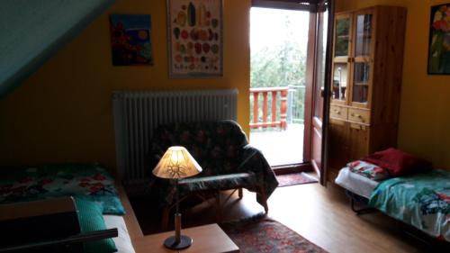 a living room with a chair and a lamp at Im Baumhaus in Roth