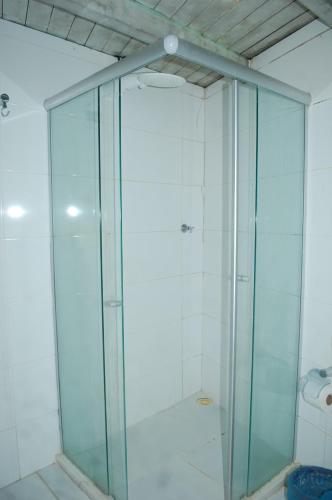 a shower with glass doors in a bathroom at neapolis in Morro de São Paulo