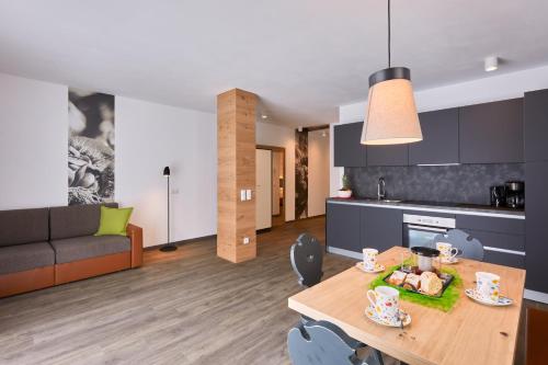 a kitchen and living room with a table and a couch at Residence Laitacherhof - Modern Apartments with Sauna in Chiusa