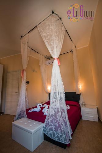 a bedroom with a canopy bed with curtains at La Gioia di Sicilia B&B in Avola