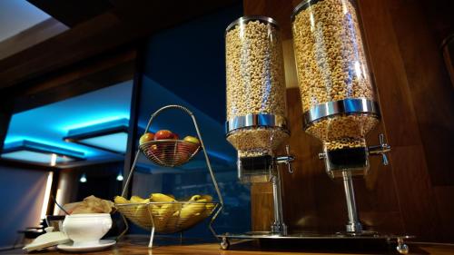 two lights on top of a table with a bowl of fruit at Hôtel Le Rivage in Rosemère
