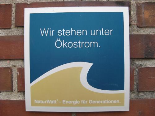 a sign on the side of a brick wall at Hotel Pension Loose in Borkum