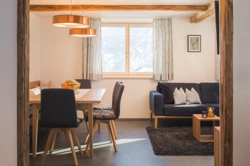 uma sala de jantar e sala de estar com mesa e cadeiras em Villa Mulin im Sommer inklusive Bergbahnticket Super Sommer Card em Ladis