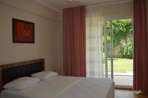 a bedroom with a bed and a large window at Sultan Homes Apartments 2 in Kemer