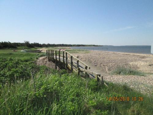 a boardwalk on a beach next to the water at Bakkegården Homestay in Spottrup