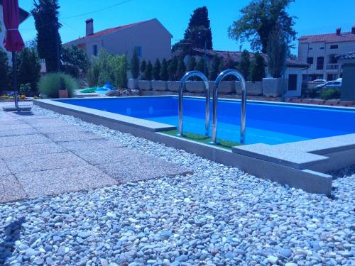 a swimming pool with two metal hand rails next to it at Holiday Home ZEN in Fažana