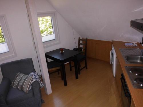 a small room with a table and a kitchen with a stove at Haus Droste in Husum