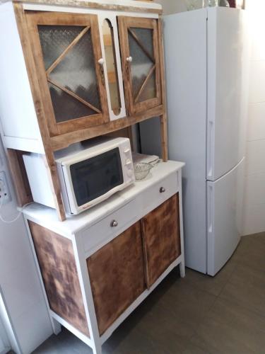 a microwave on a counter next to a refrigerator at La Casina de La Virgen del Camino VUT-LE-113 in La Virgen del Camino