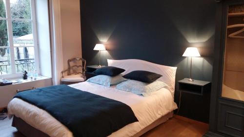 a bedroom with a large bed with two pillows at Entre Hotes in La Rochelle