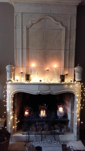 a fireplace with christmas lights in a living room at Entre Hotes in La Rochelle