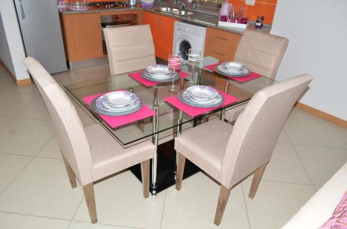 a dining room table and chairs with pink napkins at Apartamento Cristina in Praia