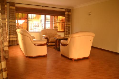 a waiting room with chairs and a table at The Palms Beach Hotel and Restaurant Limited in Entebbe