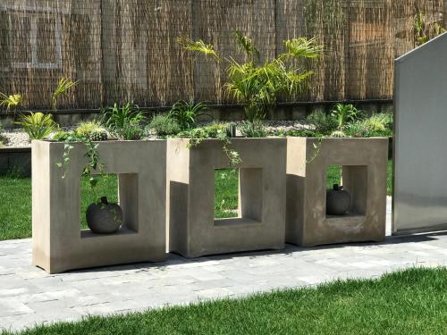 a concrete garden with two vases in the middle at Apartment Zielspitz in Parcines