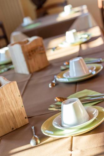 een tafel met borden en bekers en lepels erop bij Malga Zebari in Velo Veronese