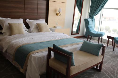 أجنحة أرال في الرياض: غرفة نوم بسرير كبير مع كرسي ازرق