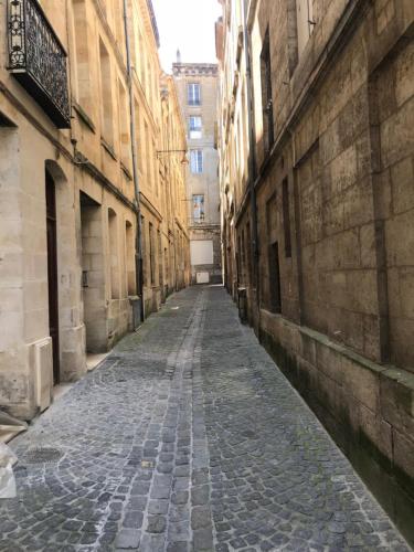 una calle vacía en un callejón entre edificios en Le triangle d or en Burdeos