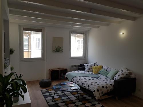 un salon avec un canapé et deux fenêtres dans l'établissement Superbe T2 Vieux Port, à Marseille