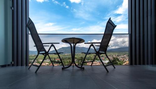 a table and two chairs in front of a large window at Hotel Christof in Appiano sulla Strada del Vino
