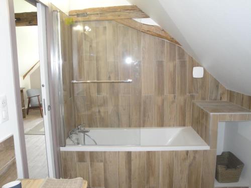 y baño con bañera y paredes de madera. en La Suite Du Marquis, en Saint-Paterne-Racan