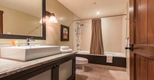 a bathroom with a sink and a toilet and a tub at Étoile du Matin by Rendez-Vous Mont-Tremblant in Mont-Tremblant