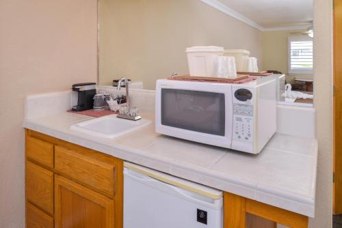 a kitchen counter with a microwave and a sink at Cayucos Beach Inn in Cayucos